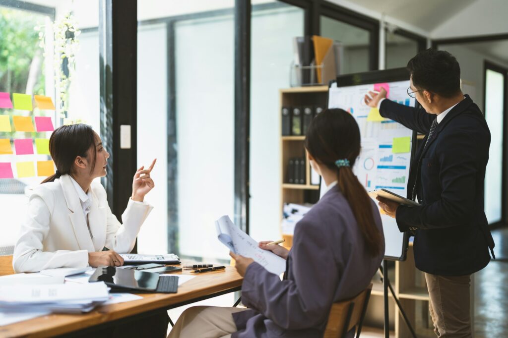 Business adviser explaining business plan strategy on flipchart.