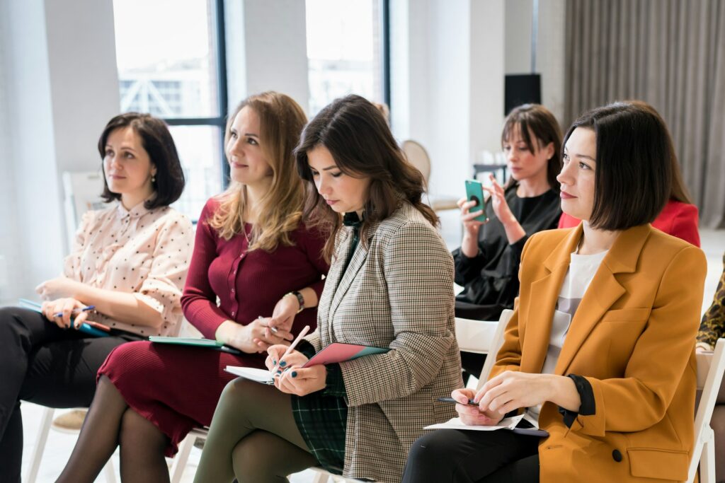 Group of females sitting in the audience for business training.