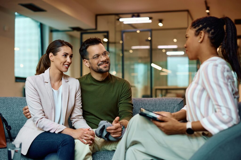 Happy couple having counseling with a financial advisor in the office