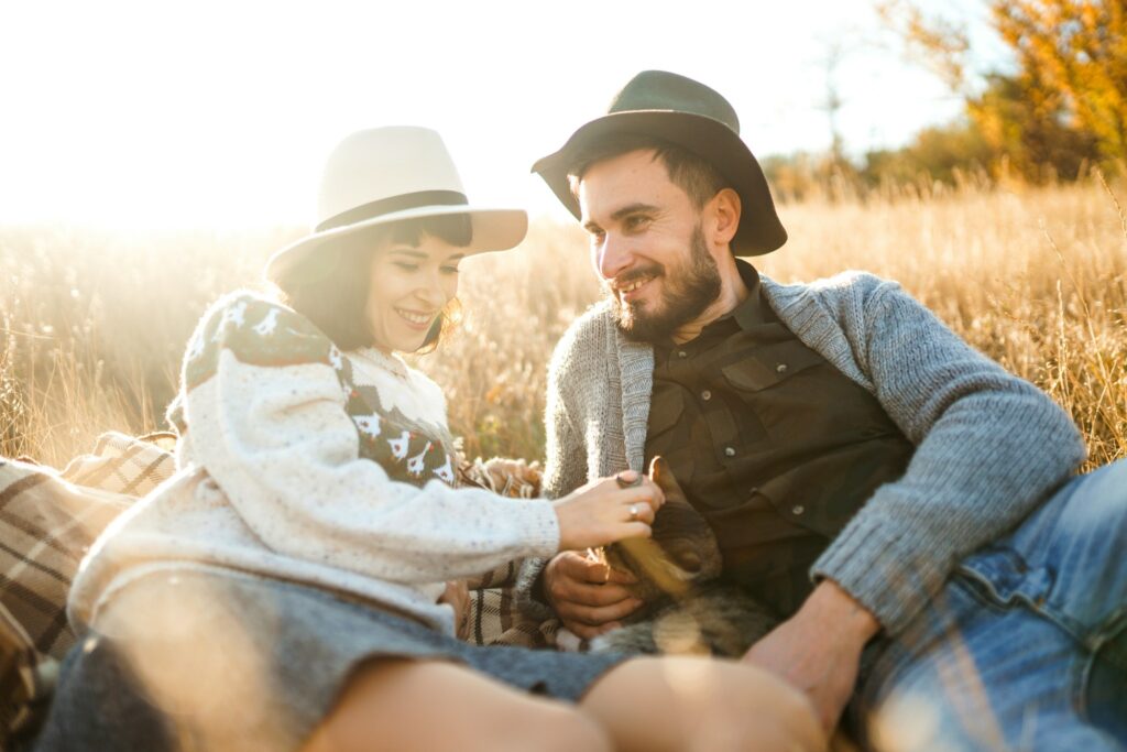 Lovely hipster couple with cat. Couple wearing beautiful hats and sweaters. Lifestyle.