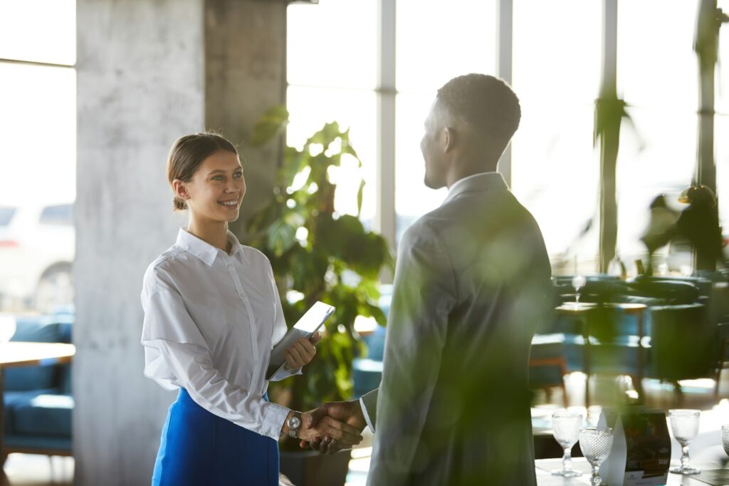 Pretty business lady shaking hand of business partner